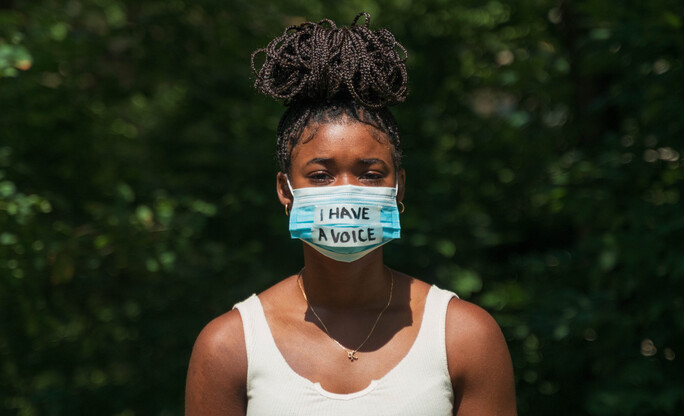 Woman wears face mask with protest message